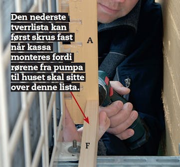 Varmepumpehus hviler på de to stålbrakettene som varmepumpa er montert på veggen med Hus til varmepumpe hviler på de to stålbrakettene som varmepumpa er montert på veggen med